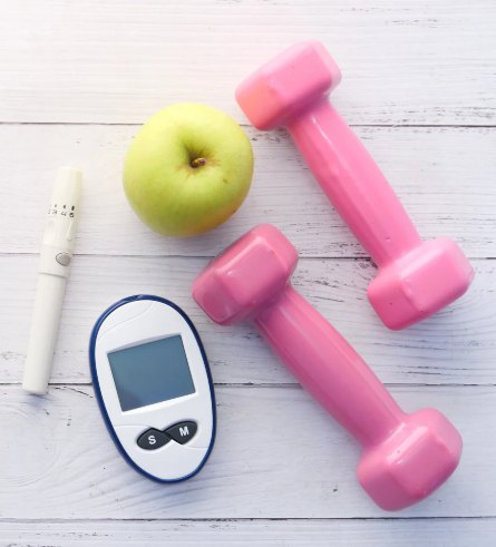 Glucose meter, lancing device, green apple and pink hand weights